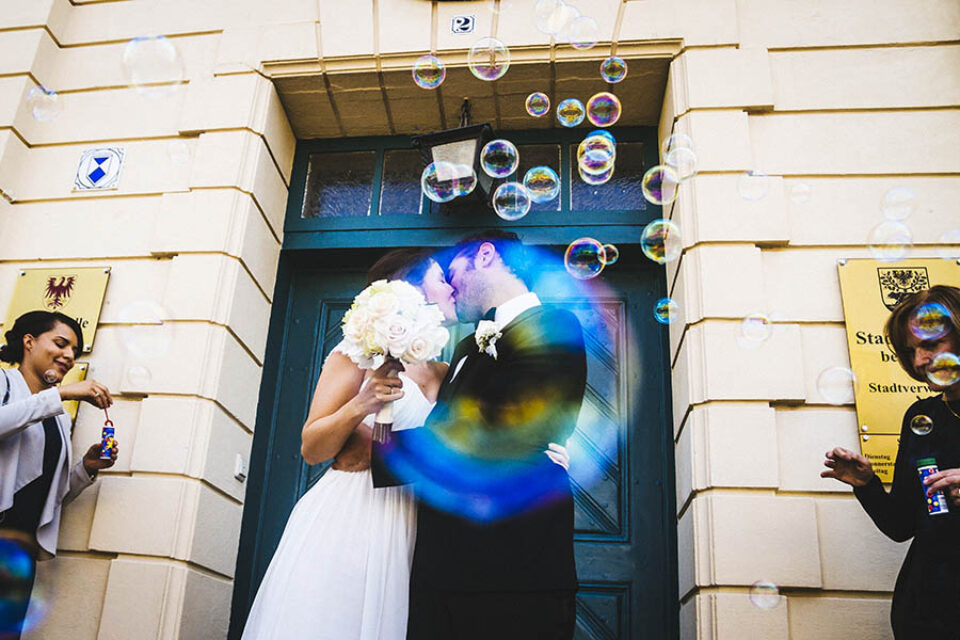 Newlyweds kissing through soap bubble