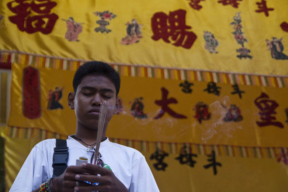 Young man praying with incense