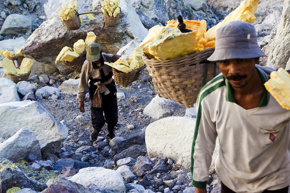 Miners carrying sulphur out of the crater