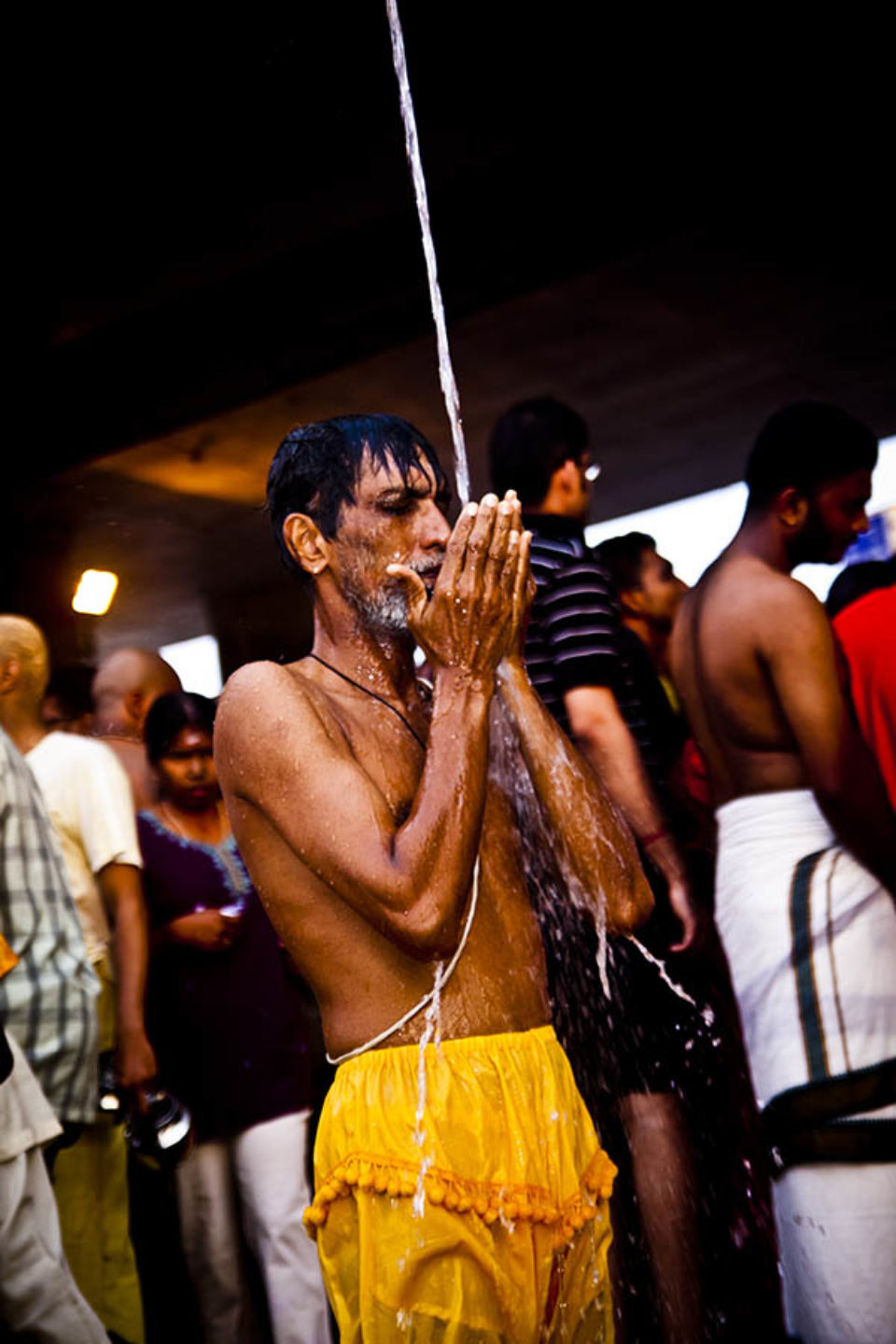 A devotee praying under stream of water