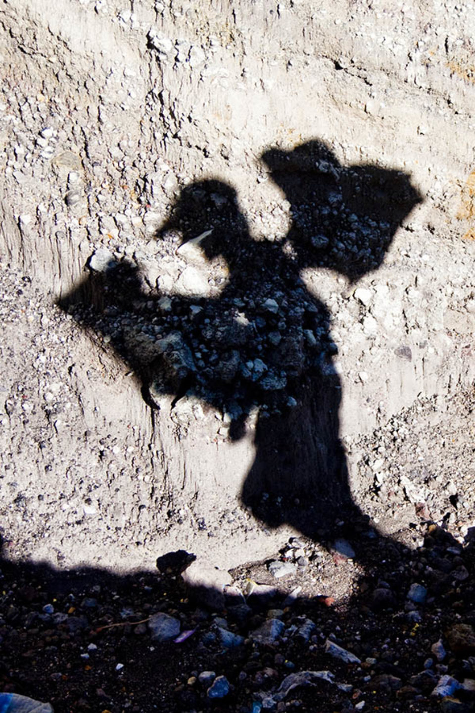 Shadow of sulphur miner carrying load