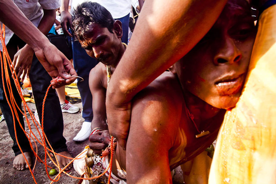 Celebrant waiting for kavadi to be hooked into his back