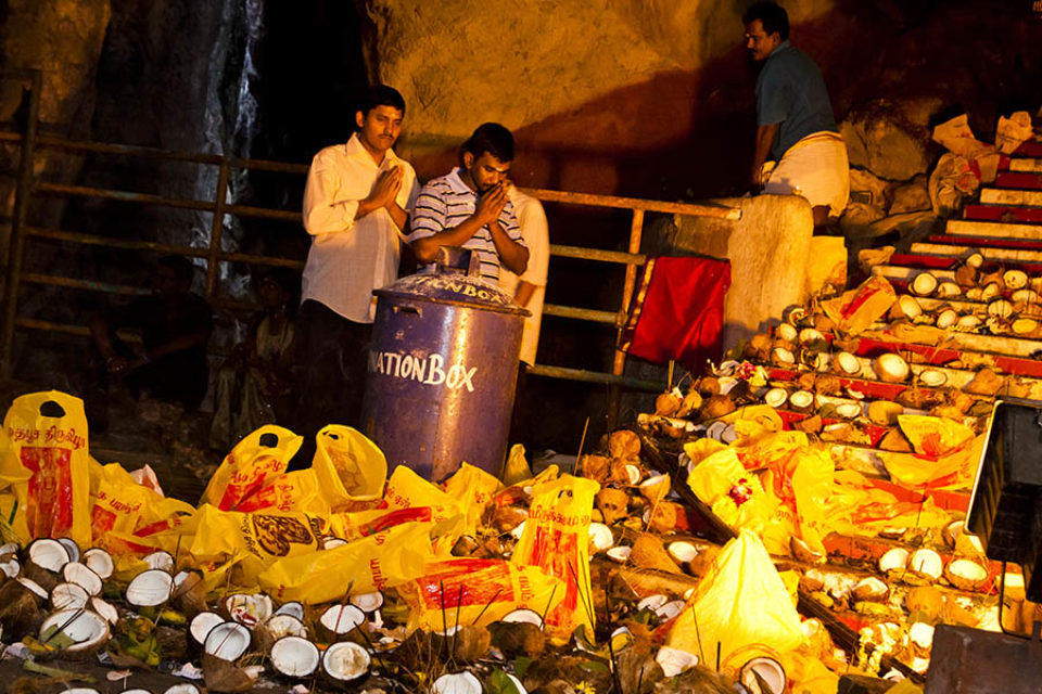 Men praying inside Batu Caves