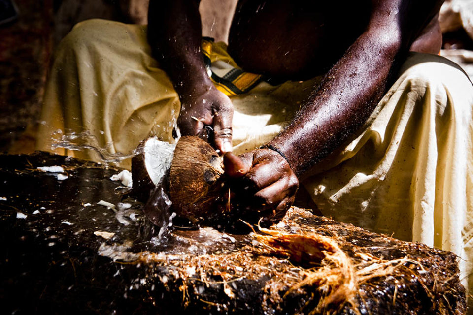 Priest smashing coconut