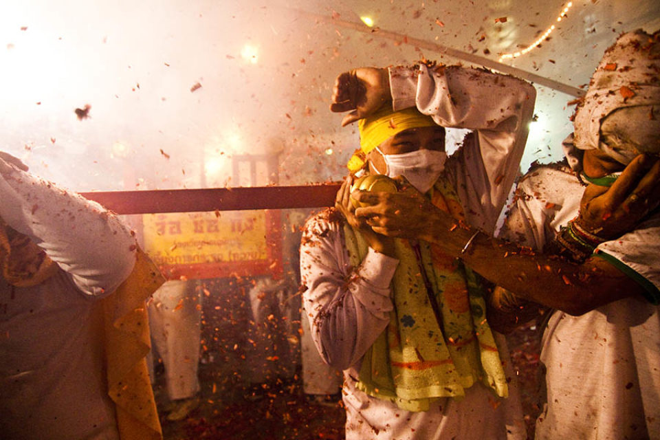 Firecrackers explode over night procession