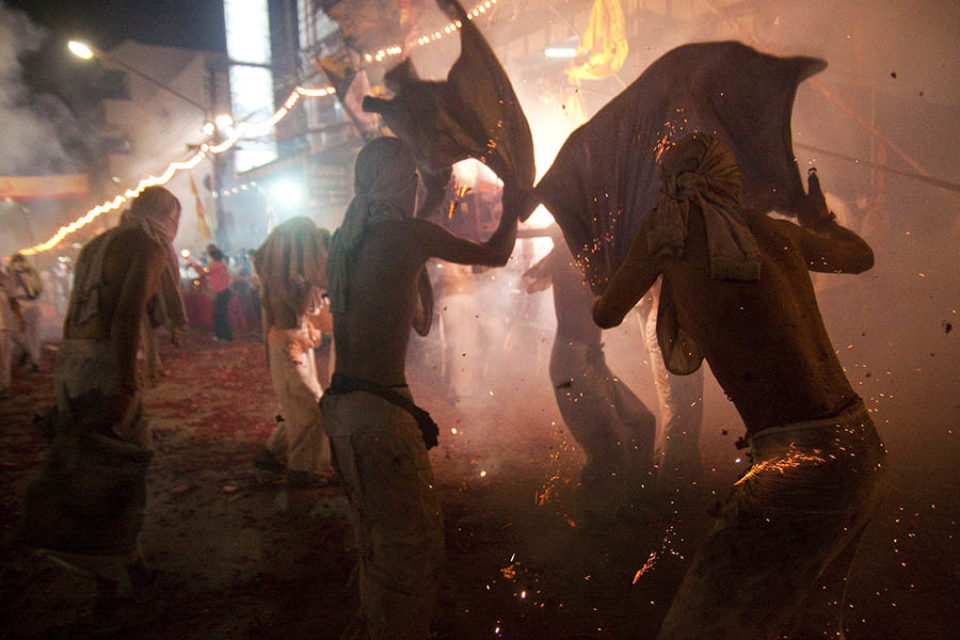 Firecracker sparks over litter during night procession