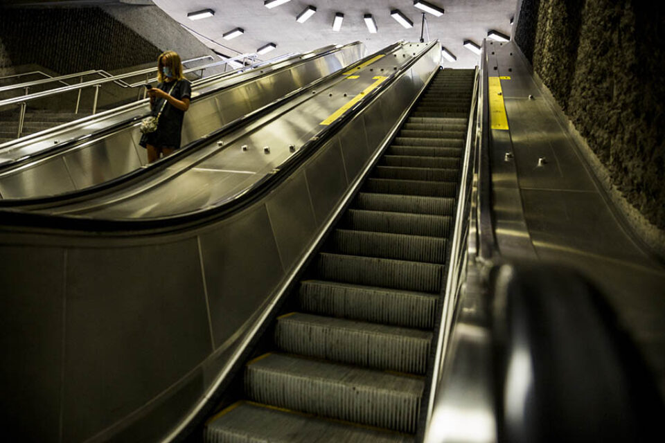 Woman on metro station escalators