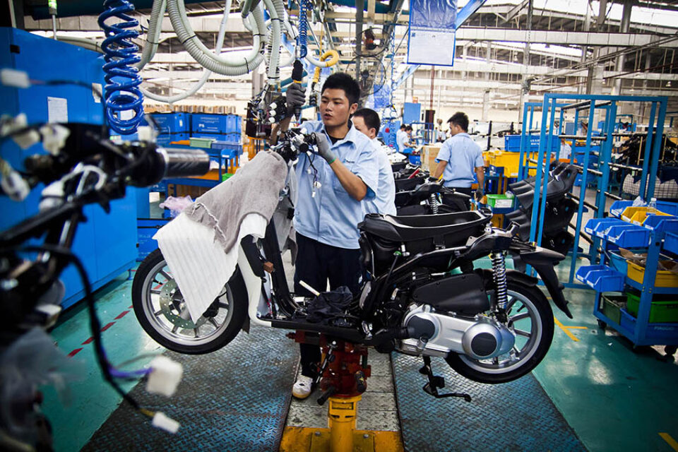 Worker assembling scooter on Piaggio production line