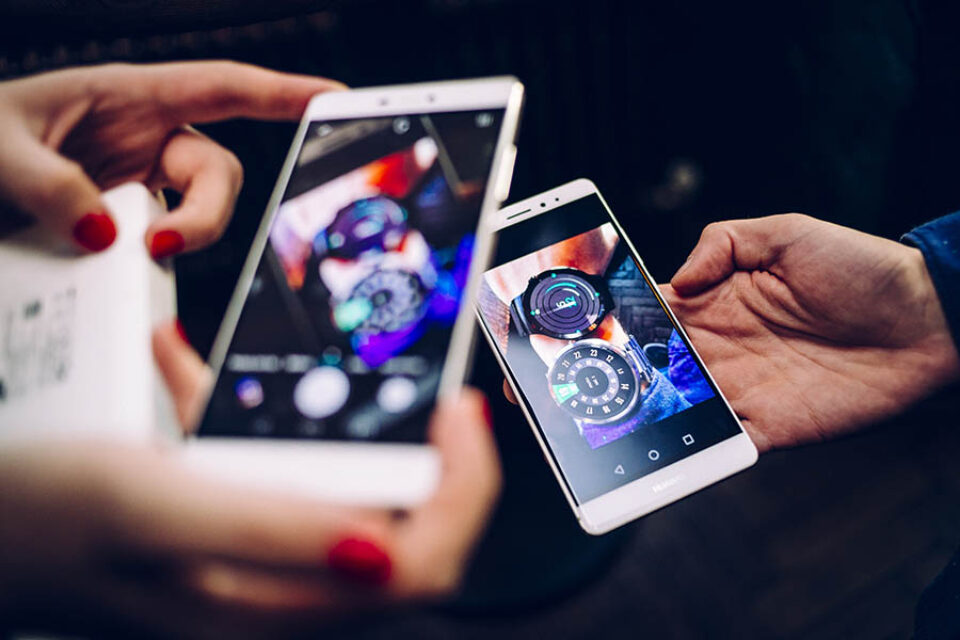 People photograph smartwatches with smartphones by a Montreal event photographer