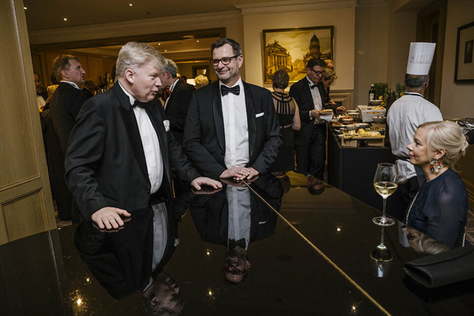 Event guests talk at piano