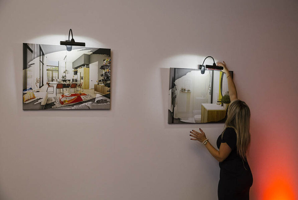 Woman hangs corporate art for a Montreal event