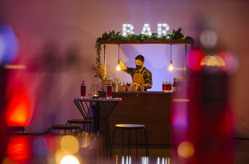 Barman pours drink at event bar