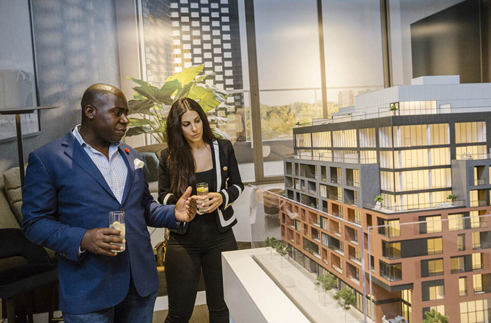 Broker shows client condo scale model at a corporate event in Ottawa