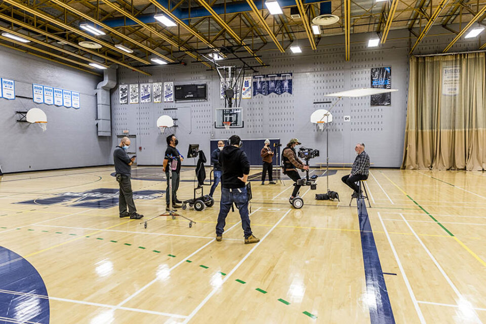 Film crew in gymnasium