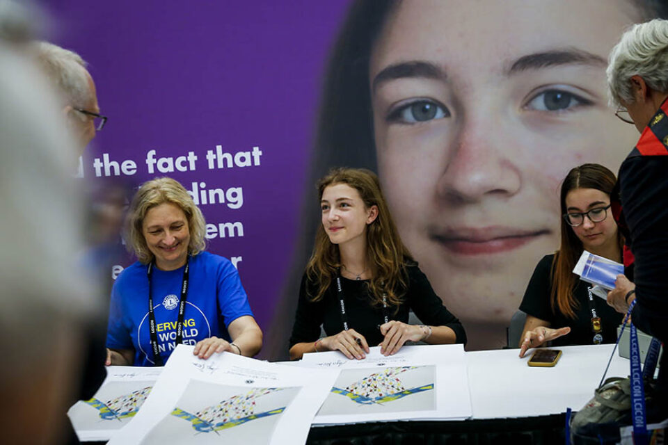 Young artist autographing her artwork at a convention in Montreal