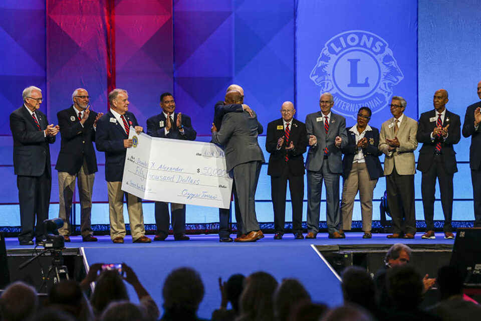 Outgoing Lions Club president presented with cheque onstage in Montreal