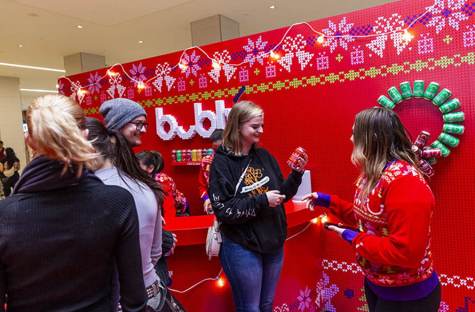 Woman looking at can of Merry Berry Buble sparkling water at an event in Montreal