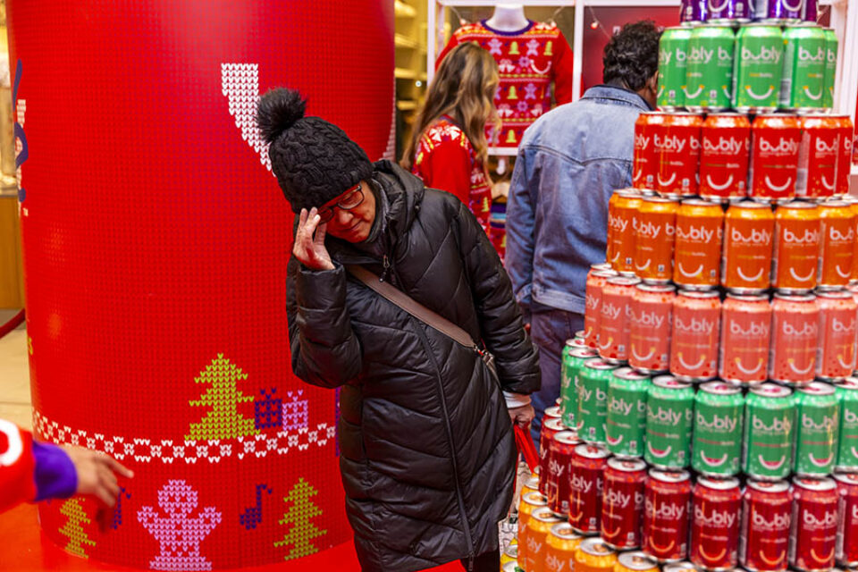Woman looks at tower of Bubly cans