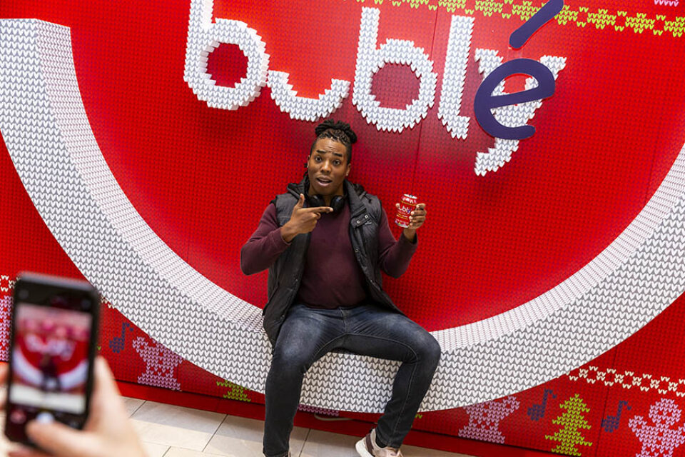 Person posing for photograph at Bubly stand
