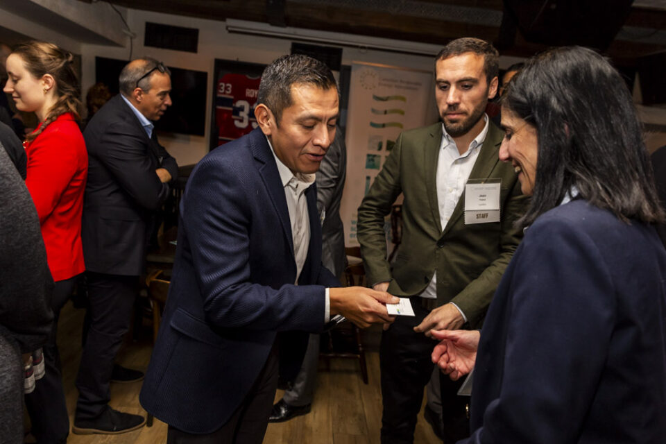 Corporate event delegates exchange business cards at a networking event in Montreal