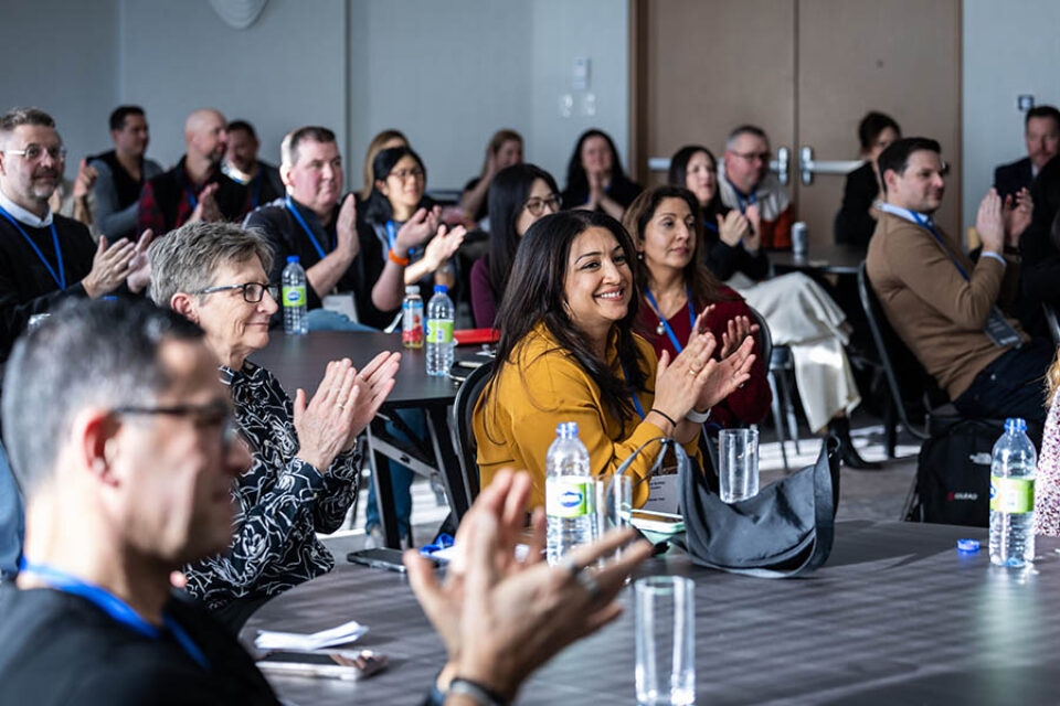 Event attendees applaud a speaker, shot by Montreal conference photographer