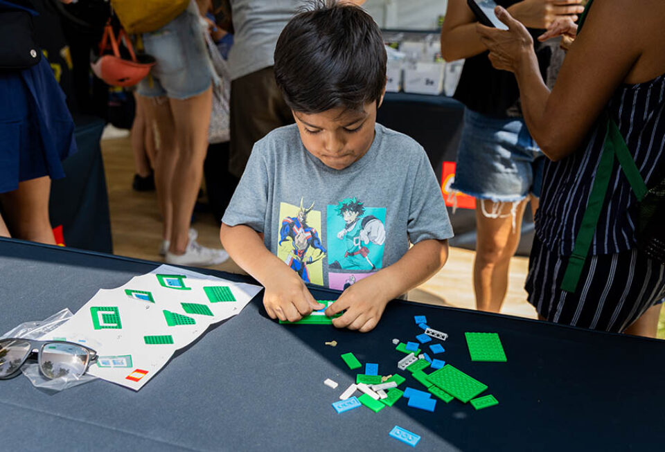Boy builds at tennis-themed LEGO brand activation in Montreal