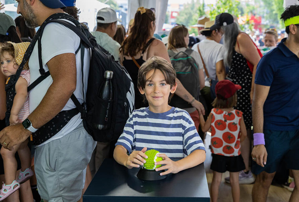 Montreal sports event photographer shot of a boy with LEGO tennis ball at Montreal tennis tournament