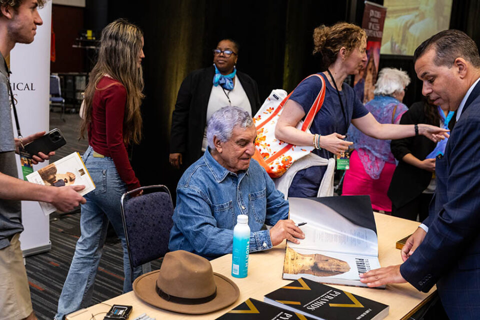 Dr Zahi Hawass signs merchandise at his Montreal event