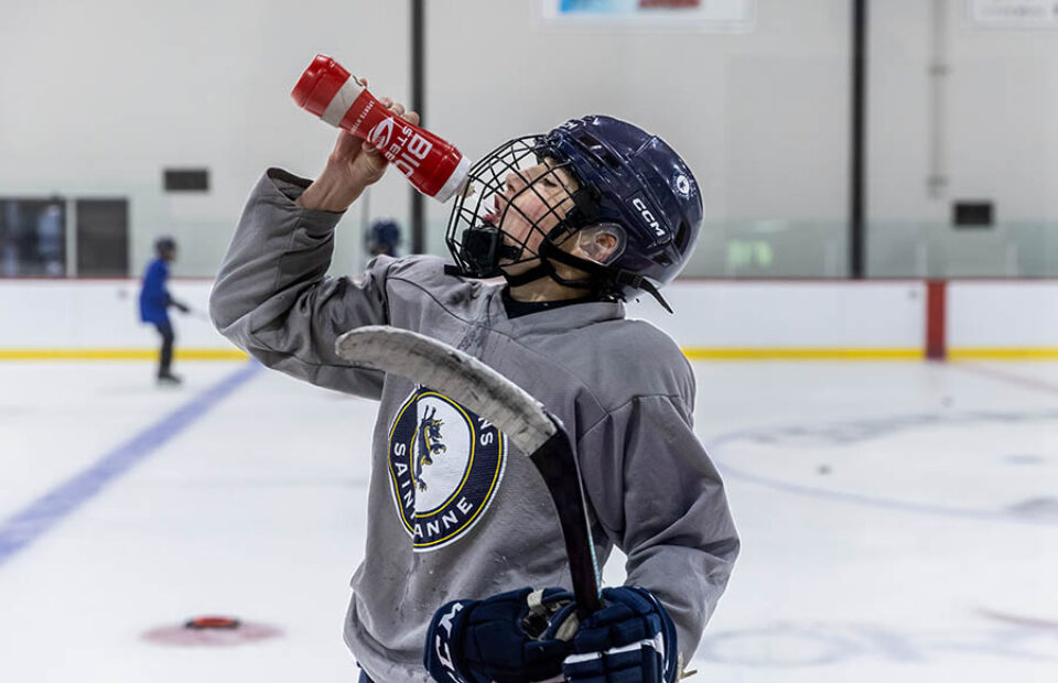 College hockey player drinking, by Montreal college sports photographer