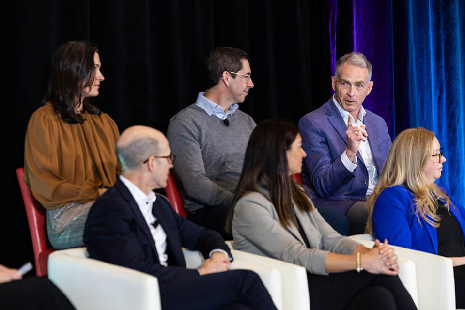 Business event panelists gesturing